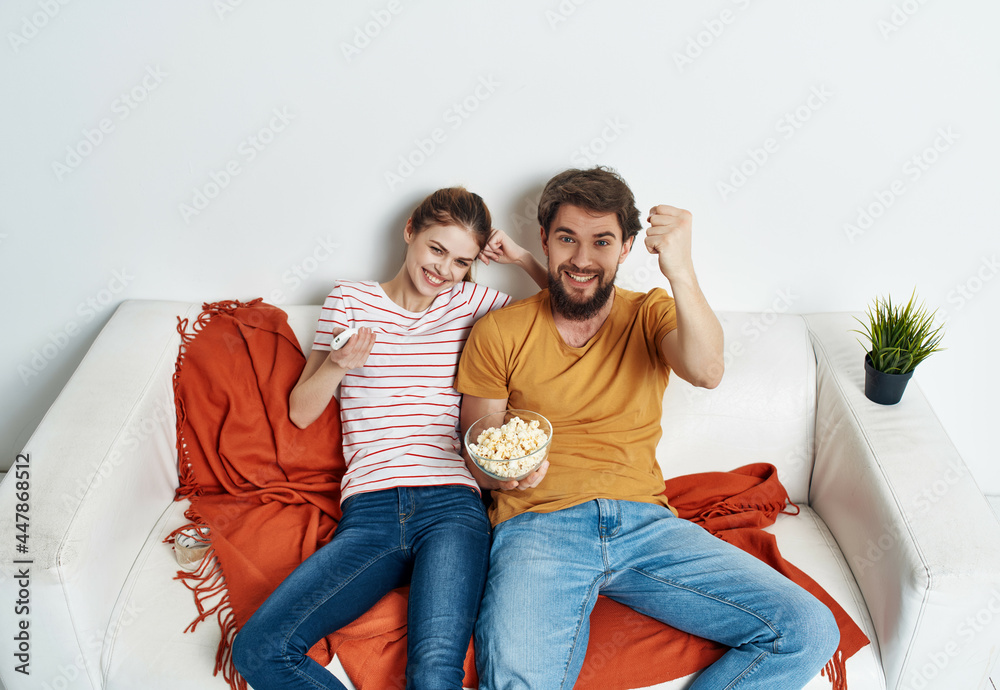 young couple sitting on the couch popcorn watching a movie vacation family young couple sitting on the couch popcorn watching a movie vacation family