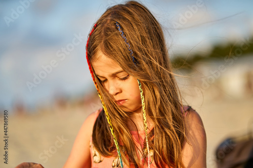 Portrait of a happy little girl on the beach during sunset