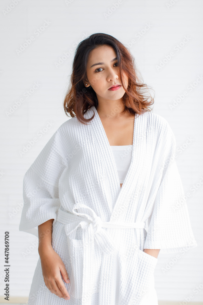 Asian woman are wearing white dress to do spa in gray background, beautiful Asian women. Stand holding hands in white spa clothes. Asian woman are wearing white dress to do spa in gray background, beautiful Asian women. Stand holding hands in white spa clothes.