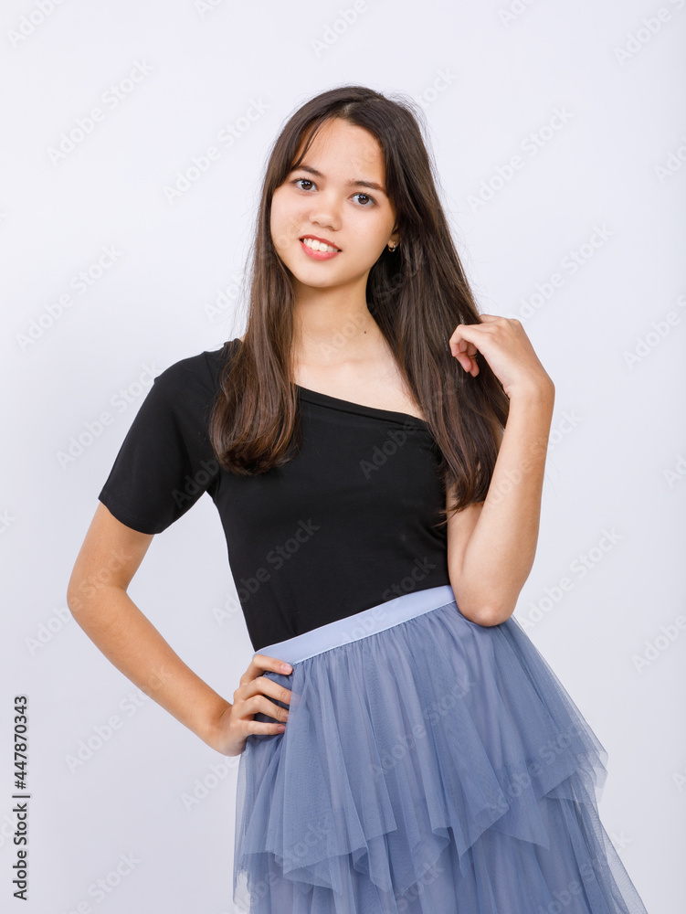 Vertical half-body portrait shot of a junior young Thai-Turkish teenager in a black dress looking at camera in the studio isolated with white background. Beautiful adolescent girl Vertical half-body portrait shot of a junior young Thai-Turkish teenager in a black dress looking at camera in the studio isolated with white background. Beautiful adolescent girl
