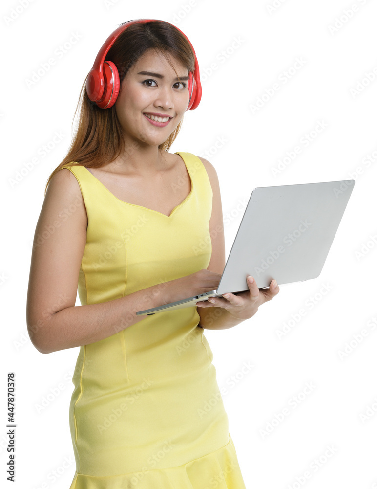 Isolated portrait close up shot of Asian happy female teenager wear large red headphones stand smiling look at camera hold laptop computer in hand listening to music Isolated portrait close up shot of Asian happy female teenager wear large red headphones stand smiling look at camera hold laptop computer in hand listening to music