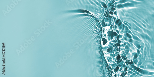 Defocused blue liquid colored clear water surface texture with splashes bubbles with copy space. Water waves in sunlight background. Trendy summer nature banner.	 photo