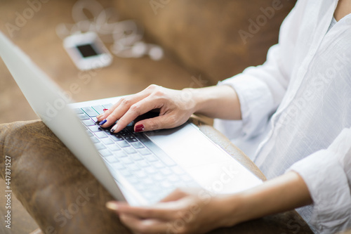 a business woman typing a notebook at her home woman working in home office keyboard hand.