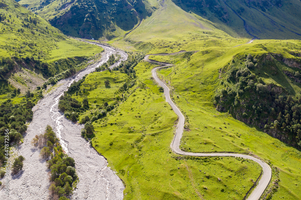 Drone view of road in Balkarsky Cherek valley on sunny summer day. Kabardino-Balkaria, Caucasus, Russia. Drone view of road in Balkarsky Cherek valley on sunny summer day. Kabardino-Balkaria, Caucasus, Russia.