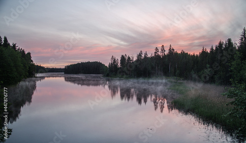 Sunrise by the lake, fog and pink sky in the early summer morning. © Bargais