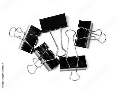 Black binder clips on white background, top view