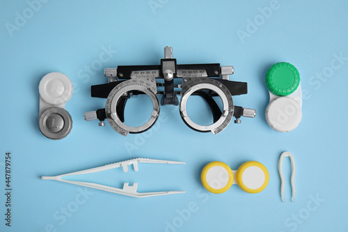 Different ophthalmologist tools on light blue background, flat lay photo