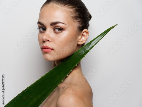 green aloe leaf on woman's shoulder side view clear skin natural look