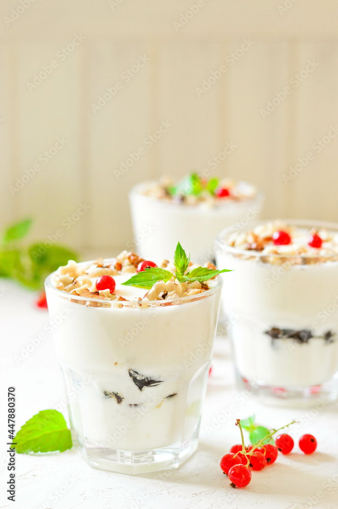 Dessert in a glass on a light background, decorated with nuts, mint leaves and berries. Creamy jelly. Parfait. Dessert in a glass on a light background, decorated with nuts, mint leaves and berries. Creamy jelly. Parfait.