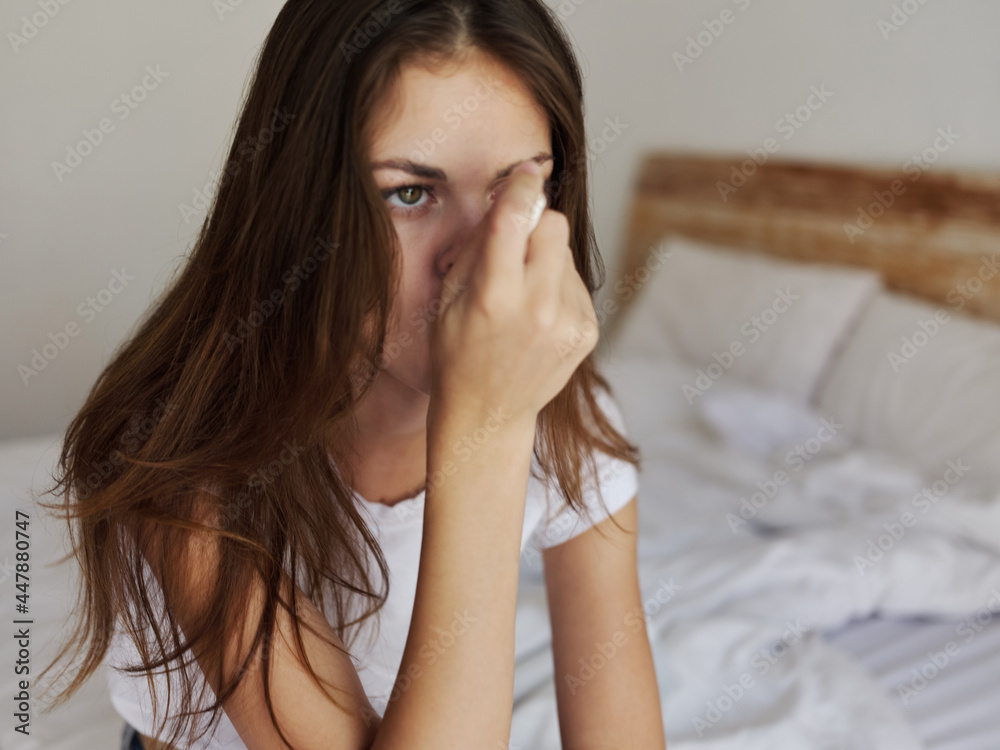 woman measures the temperature with a thermometer in her mouth in the bedroom woman measures the temperature with a thermometer in her mouth in the bedroom