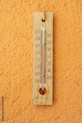 Antiguo termómetro de mercurio colgado en la pared marcando alta temperatura en verano
