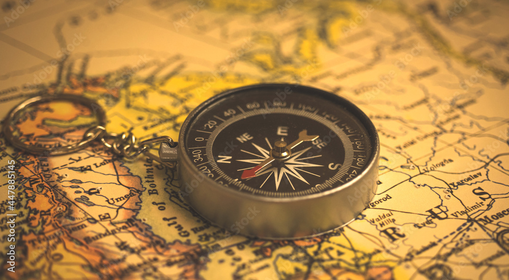 Old compass on a vintage world map, selective focus, cartography and geography concept background