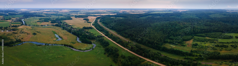 Aerial landscape of winding river in green field, top view of beautiful nature background from drone, seasonal summer landscape with copy space.