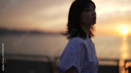 夕暮れの海を歩く女性
