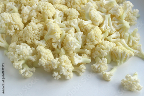 Fresh cauliflower white cabbage divided into inflorescences on a light background