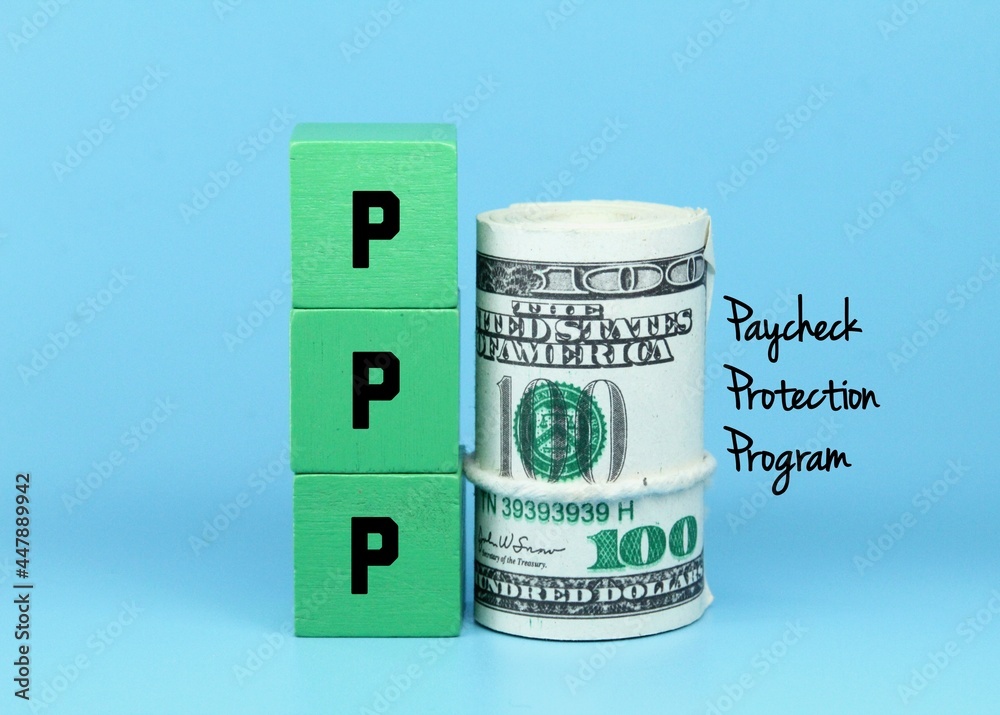 a roll of banknotes, colored cubes with the words paycheck protection program or PPP a roll of banknotes, colored cubes with the words paycheck protection program or PPP