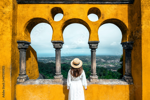 Traveler woman visiting Pena Palace in Sintra, Lisbon, Portugal. Famous landmark. The most beautiful castles in Europe photo