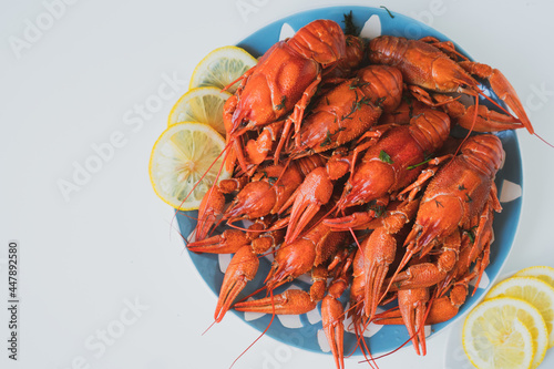 boiled crayfish served on a platter with herbs and lemon