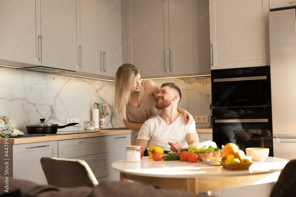 Smiling european couple on kitchen at home