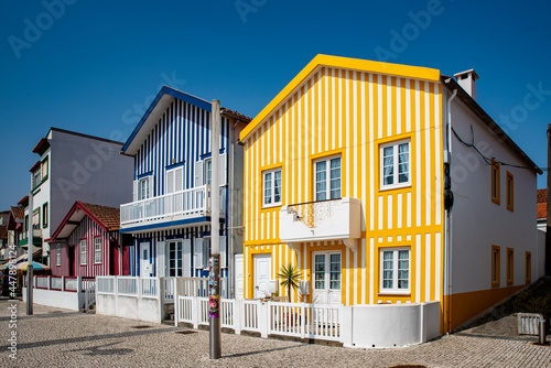 Street with colorful striped houses typical of Costa Nova, Aveiro, Portugal.