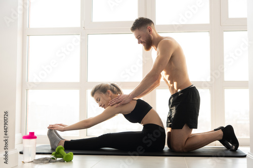 Fitness trainer showing stretching to sports woman