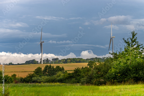 Winmill in the farmland, green fields, dark sky photo