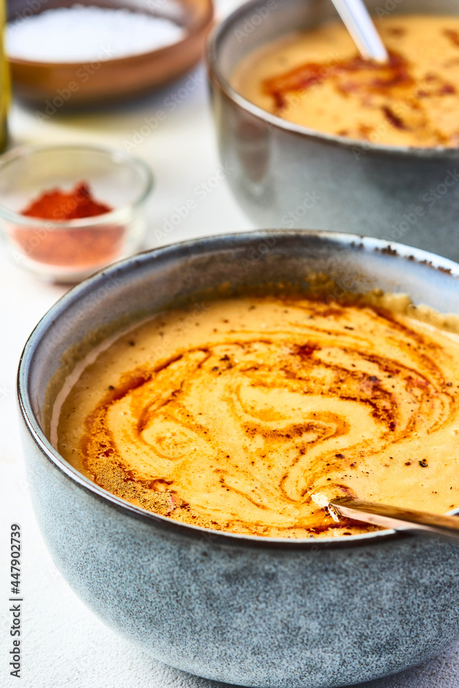 Lentil turkish yellow-coloured cream soup in a grey bowl. The second bowl is on the background. 45 angle view Lentil turkish yellow-coloured cream soup in a grey bowl. The second bowl is on the background. 45 angle view