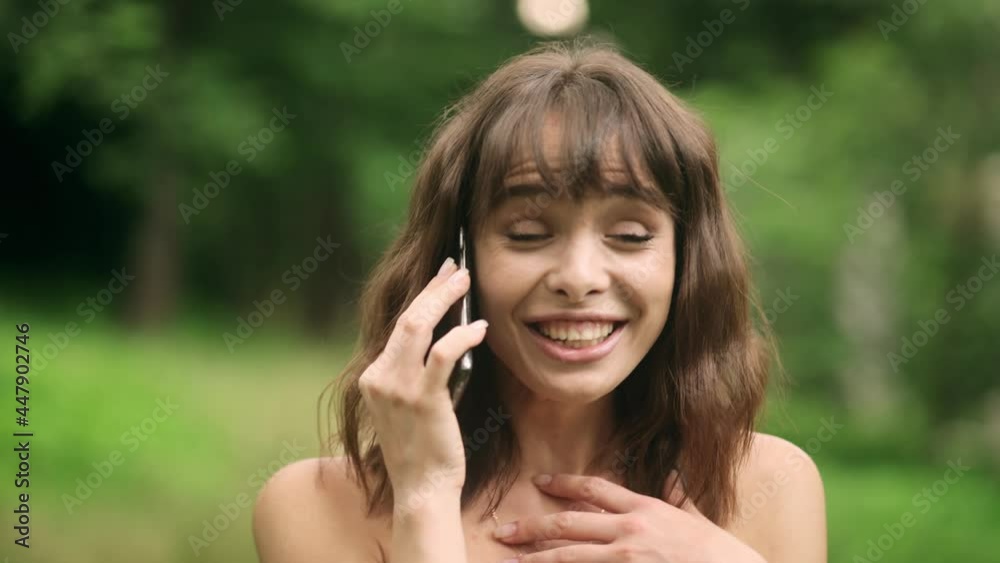 Portrait of excited young beautiful woman using mobile phone in park. Positive woman with smartphone on park road Portrait of excited young beautiful woman using mobile phone in park. Positive woman with smartphone on park road