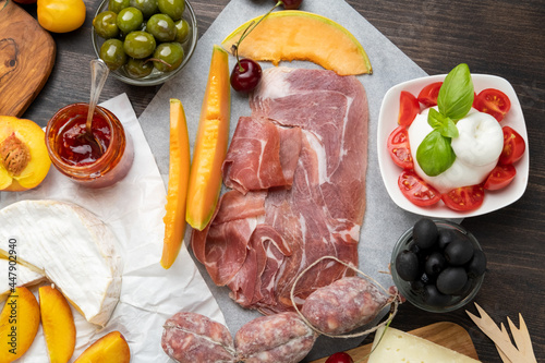Salami, prosciutto ham, olives, cherry, grape. food snacks for an aperitif, a picnic, for a festive dinner or a party. 
