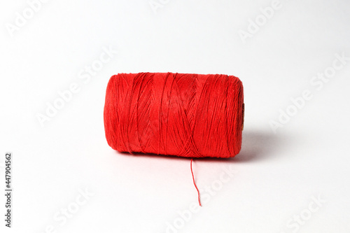 A spool of red thread. White background.