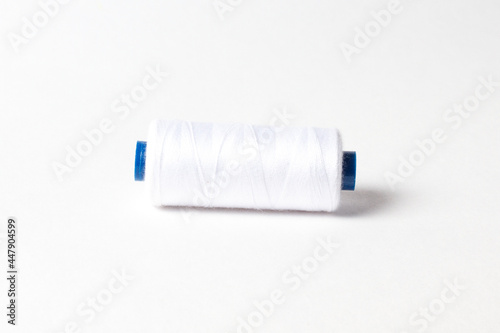 A spool of white thread. White background.