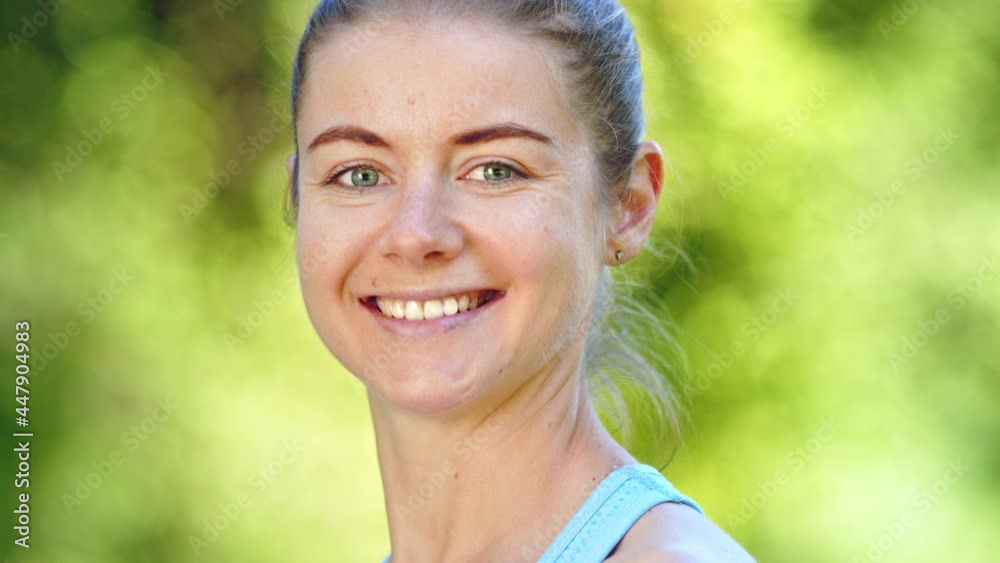 Young woman with hair bun turns head with cheerful smile Young woman with hair bun turns head with cheerful smile