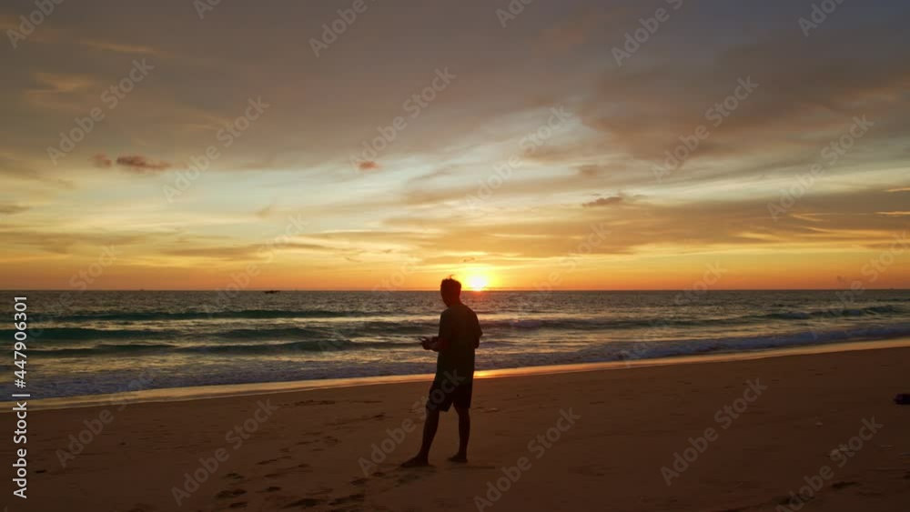 stunning colorful clouds in yellow sky at sunset..A man flying drone in stunning colorful yellow sky at sunset..Tourists piloting drones to take pictures of beautiful sunset. stunning colorful clouds in yellow sky at sunset..A man flying drone in stunning colorful yellow sky at sunset..Tourists piloting drones to take pictures of beautiful sunset.