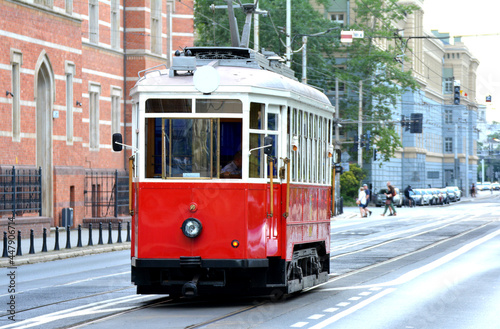 Tramwaj jedzie przez wrocław po torach z wycieczką. photo