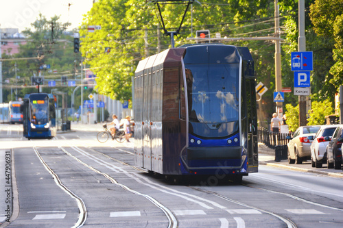 Tramwaj jedzie przez wrocław po torach z wycieczką. photo