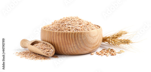 Wooden bowl and scoop with wheat bran on white background