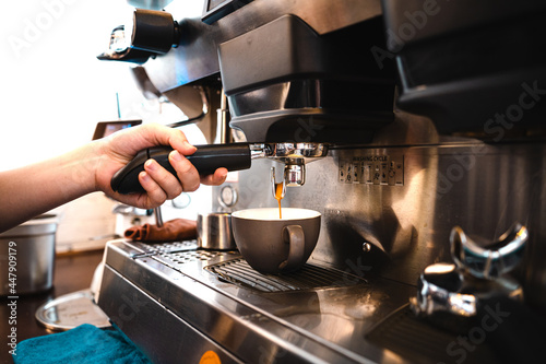 Close-up hand of barista plug the portafilter into coffee machine to make espresso