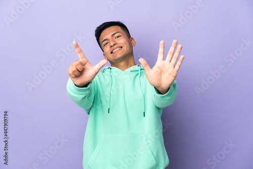 Young Ecuadorian man isolated on purple background counting seven with fingers © luismolinero