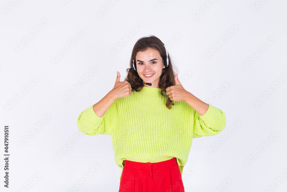 Young beautiful woman with freckles light makeup in sweater on white background with headphones helpline worker call centre manager happy smile Young beautiful woman with freckles light makeup in sweater on white background with headphones helpline worker call centre manager happy smile