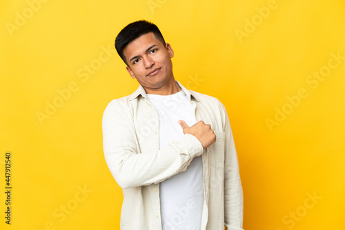 Young Ecuadorian man isolated on yellow background proud and self-satisfied