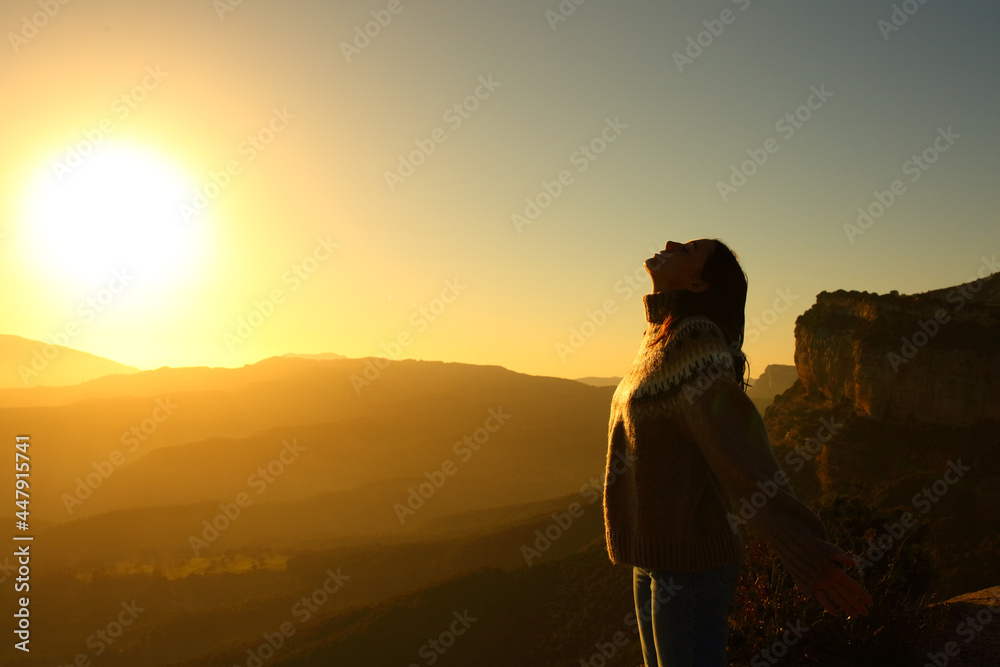 Silhouette of a woman breathing fresh air in the mountain