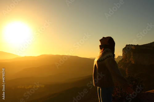 Silhouette of a woman breathing fresh air in the mountain