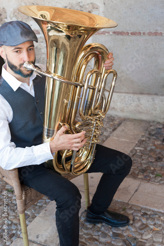 Canvas Print A jazz musician dressed in vintage style, playing the tuba on the street in broad daylight
