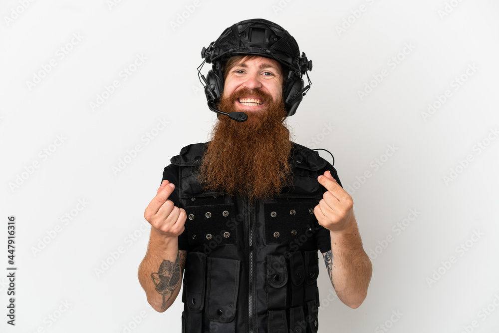 Redhead SWAT isolated on white background making money gesture Redhead SWAT isolated on white background making money gesture