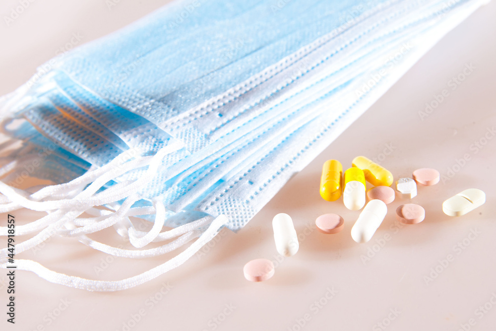 Protective face mask, surgical mask. Coronavirus concept. Surgical mask protective mask with medicine pills Protective face mask, surgical mask. Coronavirus concept. Surgical mask protective mask with medicine pills