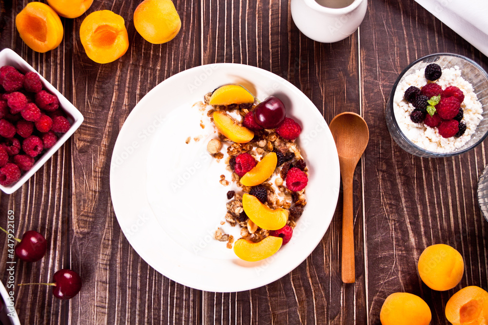 cottage cheese and yougurt with granola, berries and fruits apricot for healthy breakfast.