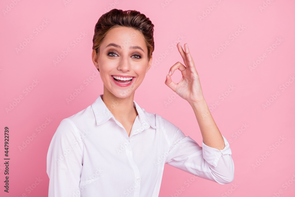 Photo of cool blond millennial lady show okey wear white shirt isolated on pink color background Photo of cool blond millennial lady show okey wear white shirt isolated on pink color background