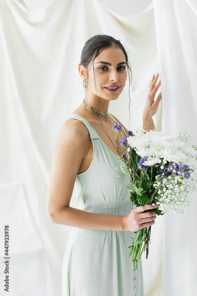 cheerful woman in dress holding bouquet of flowers on white cheerful woman in dress holding bouquet of flowers on white