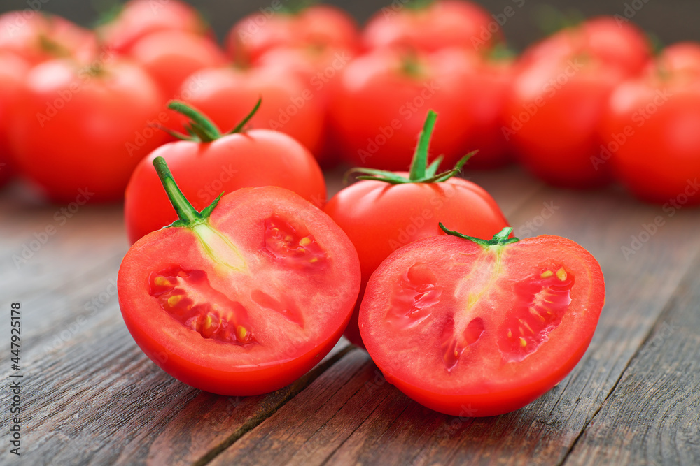 Whole and sliced fresh tomatoes on a wooden table. Whole and sliced fresh tomatoes on a wooden table.