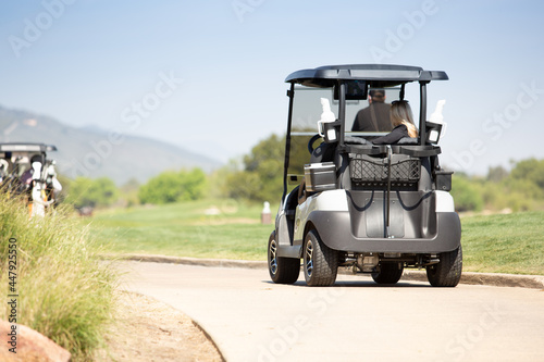 A view of a golf cart on the trail to the next golf course hole.